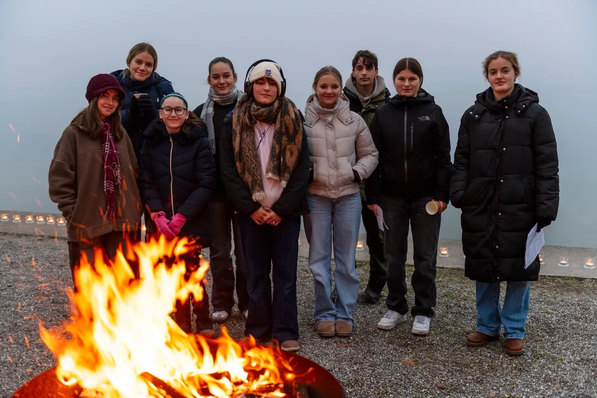 Firmlinge stehen vor dem Feuer.